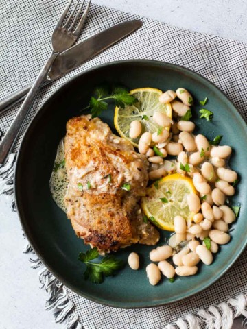 Fried chicken thigh served with white beans and lemon cream sauce.