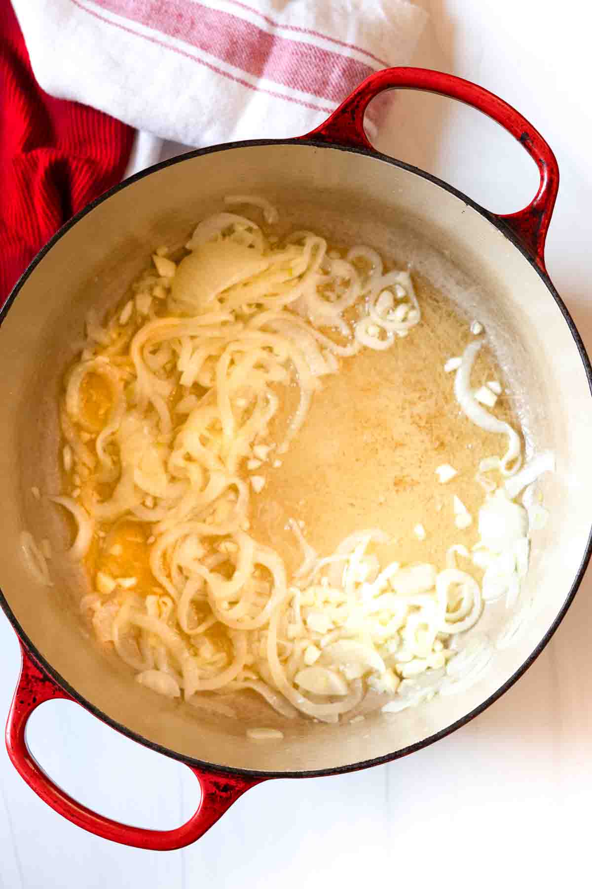 Cooking garlic and onions to make scalloped potatoes.