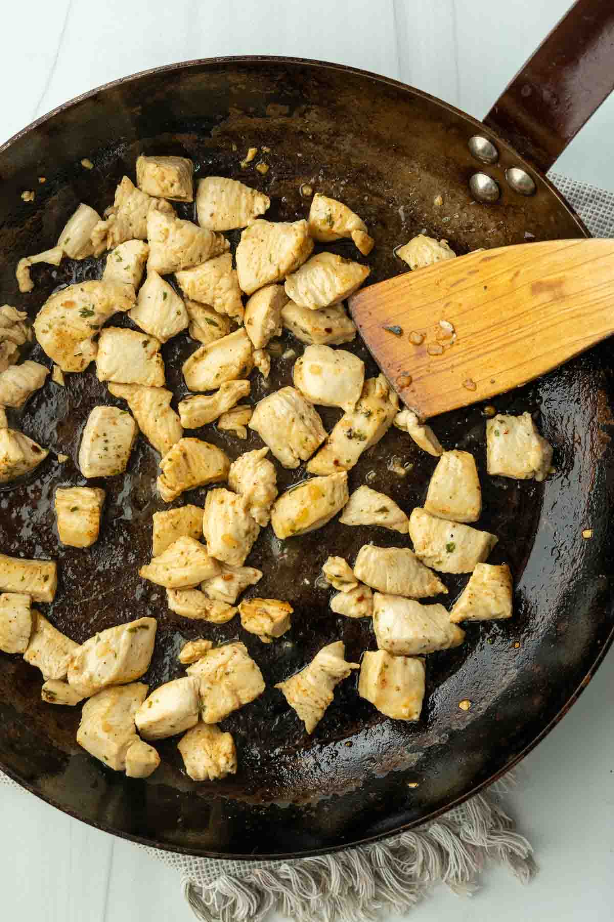 Sauteeing cubed chicken breast for Hatch chile pasta with chicken.