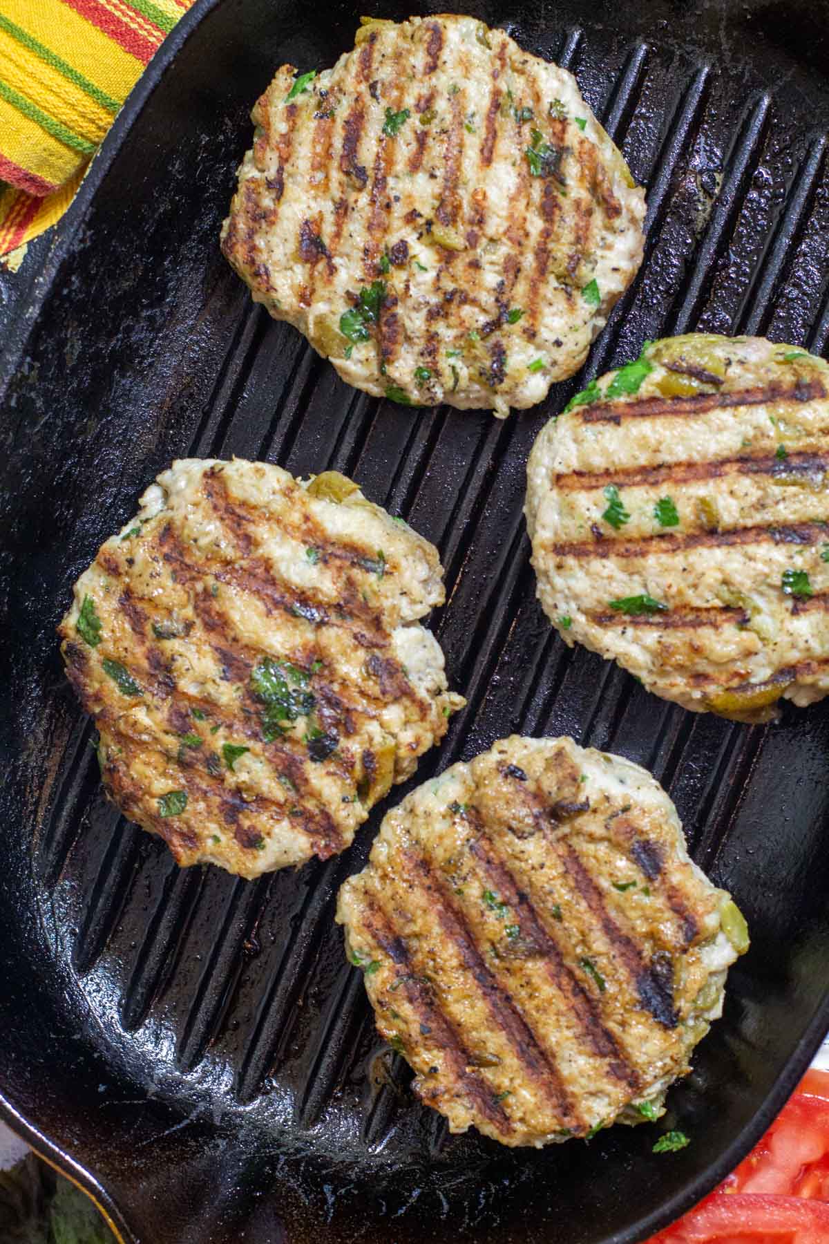 Cooking ground chicken patties stove top in a grill pan.