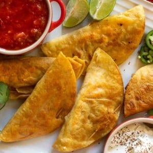 Fried tacos served with salsa and sour cream.