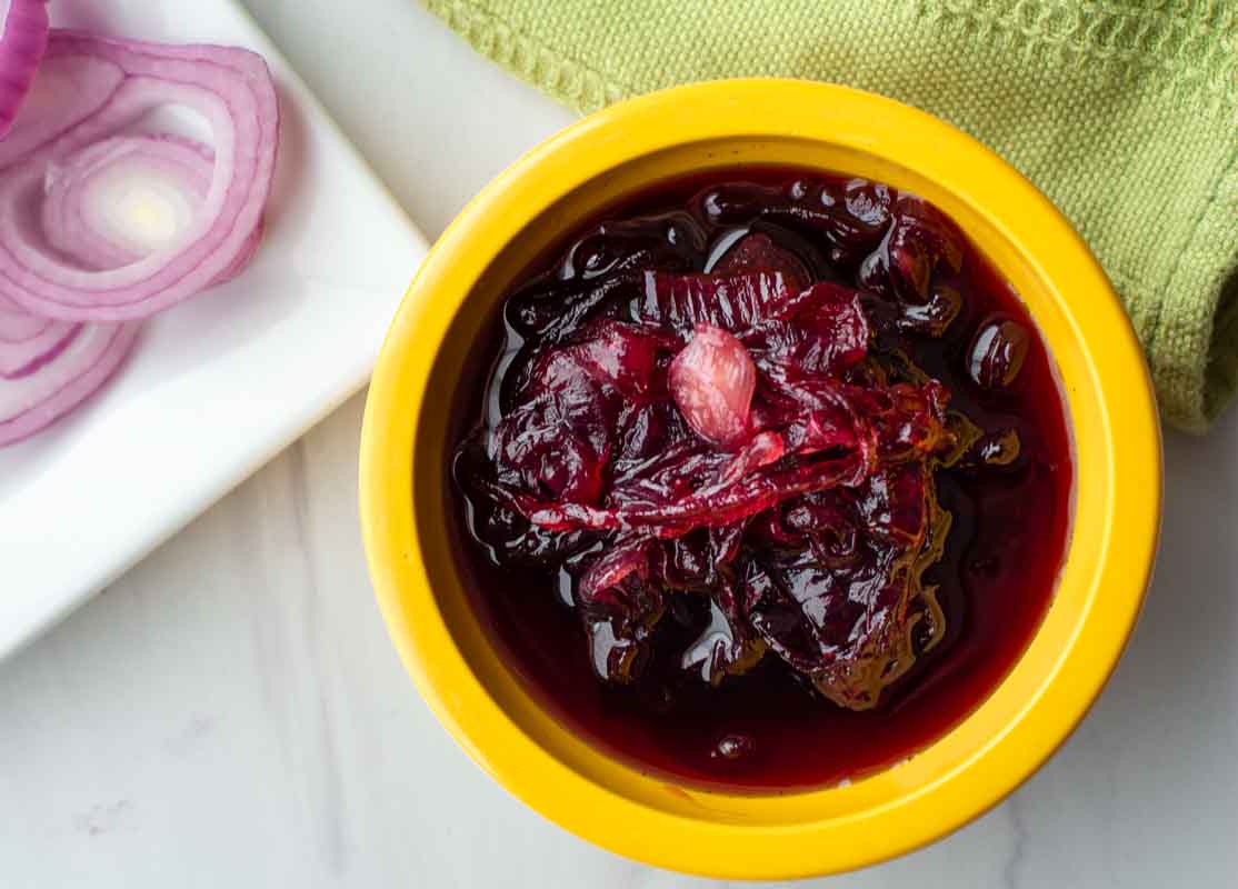 Red onion marmalade in a yellow bowl.