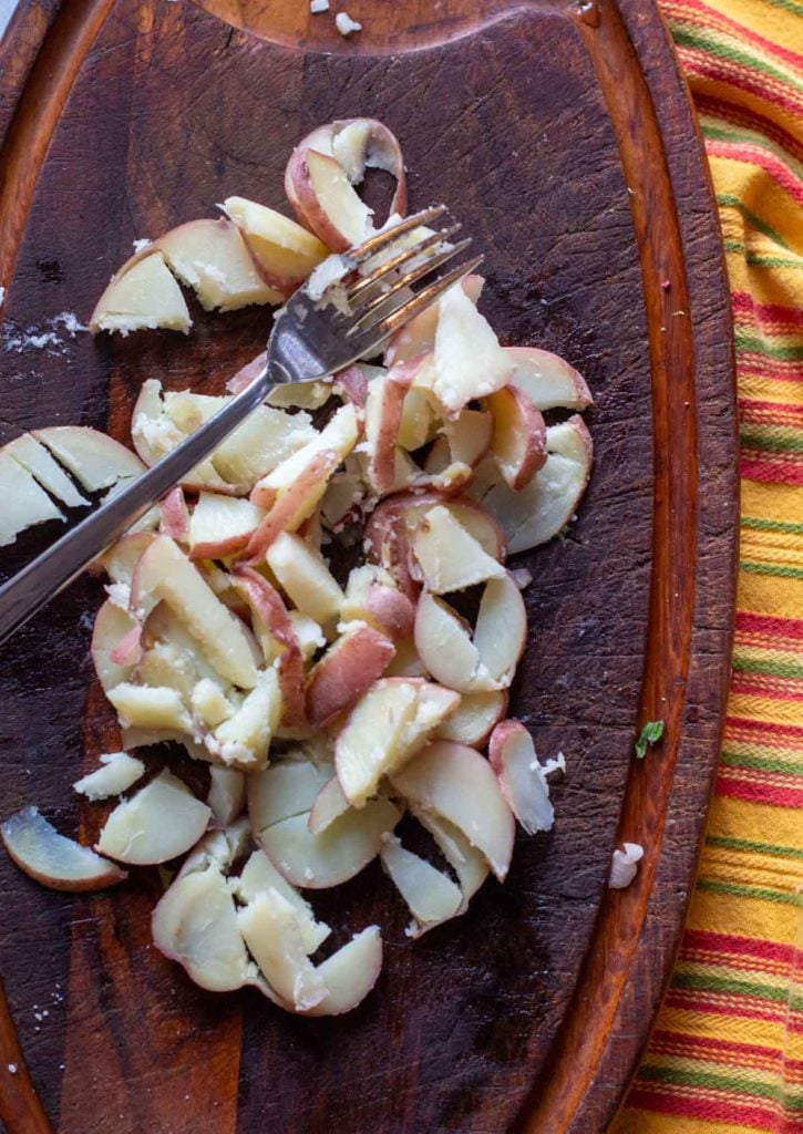 Using a fork to chop up potatoes