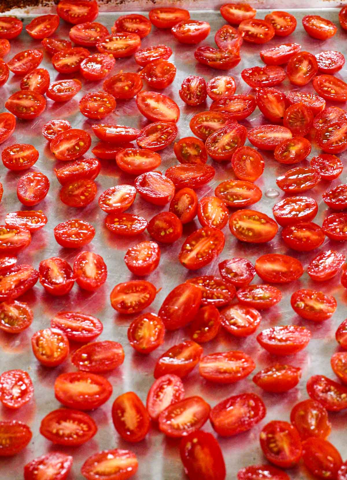 Cherry tomatoes on a sheet pan for oven roasting.