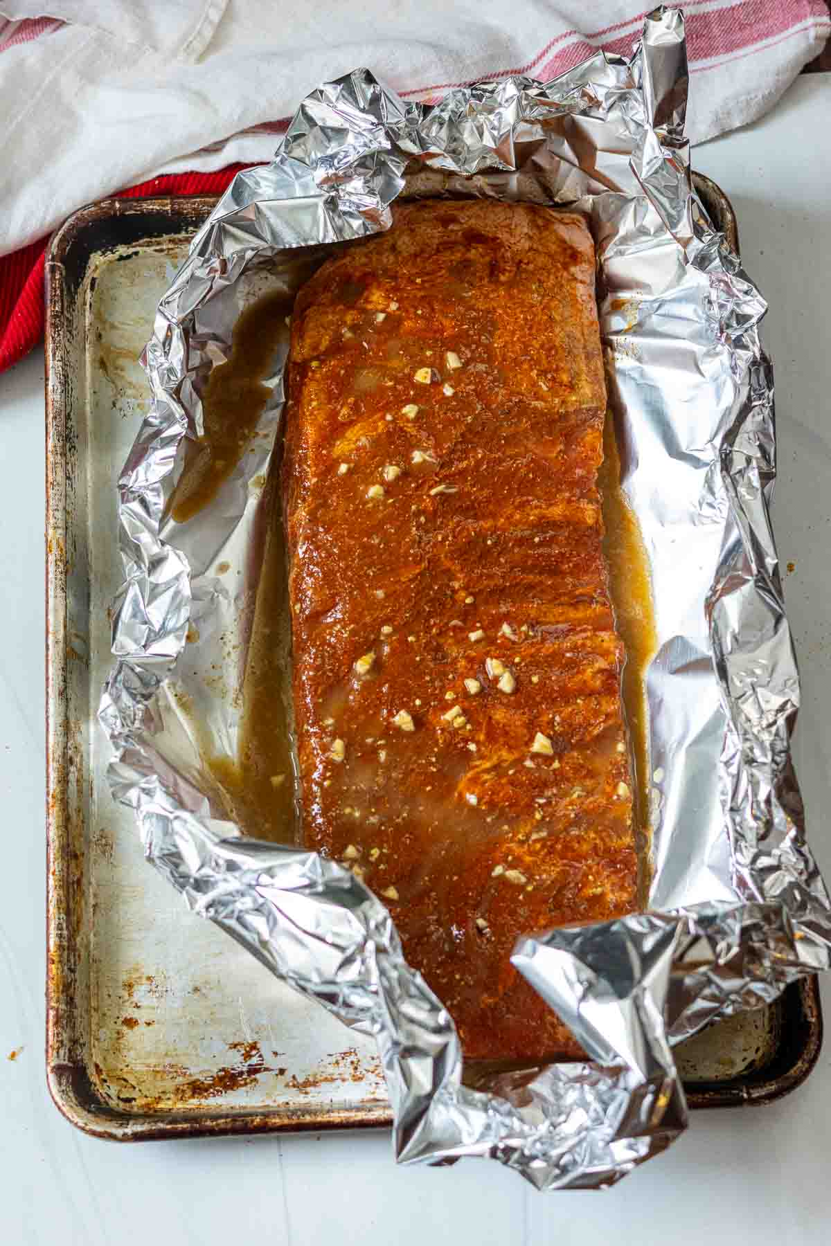 Adding beer mustard sauce to oven ribs.