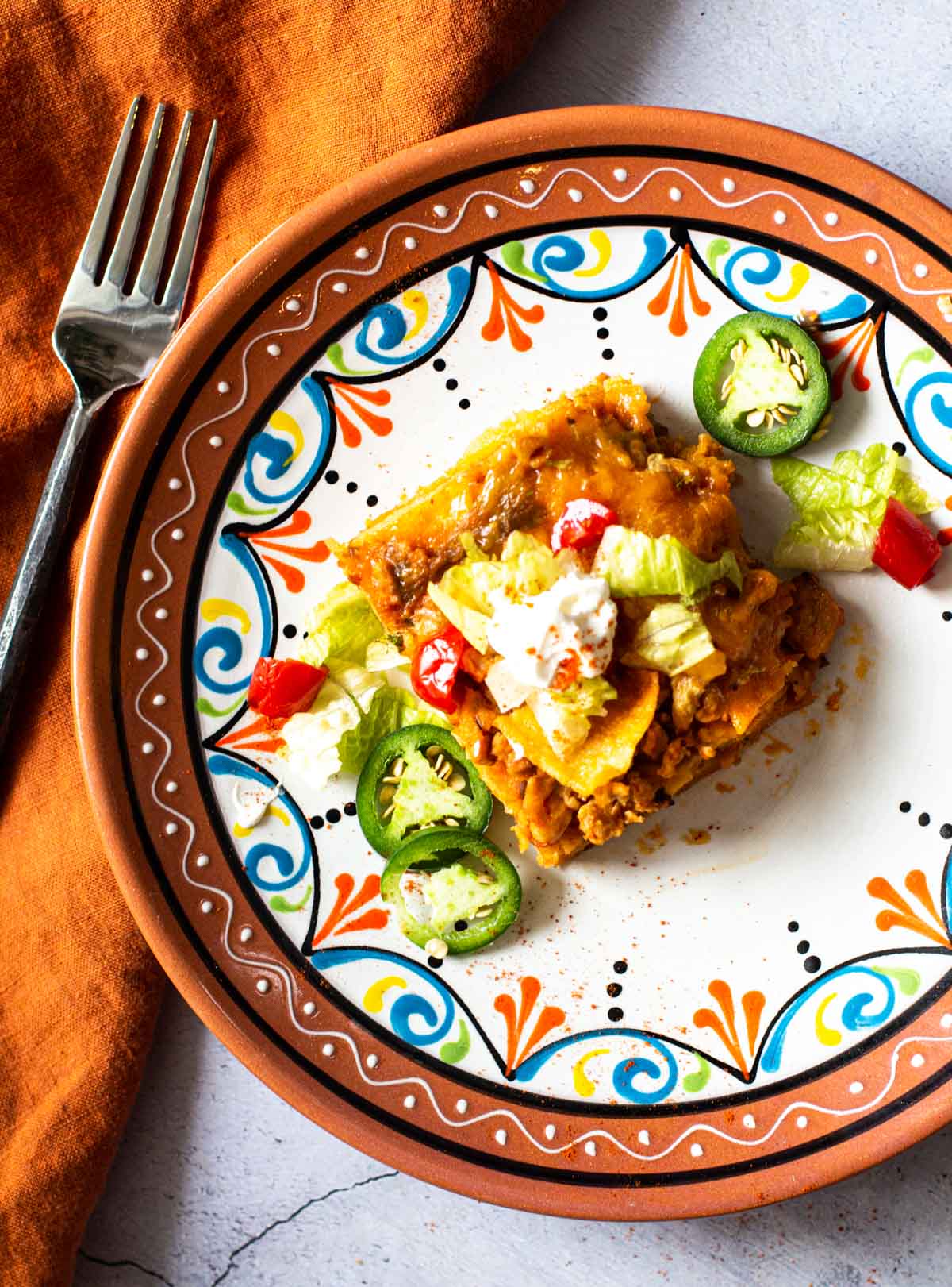 A slice of Chicken Taco Casserole on a Mexican plate. 