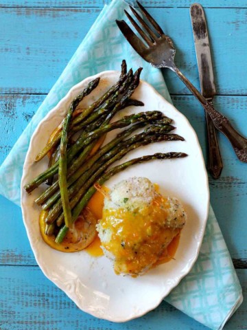 Chicken cordon bleu served with apricot sauce and asparagus.