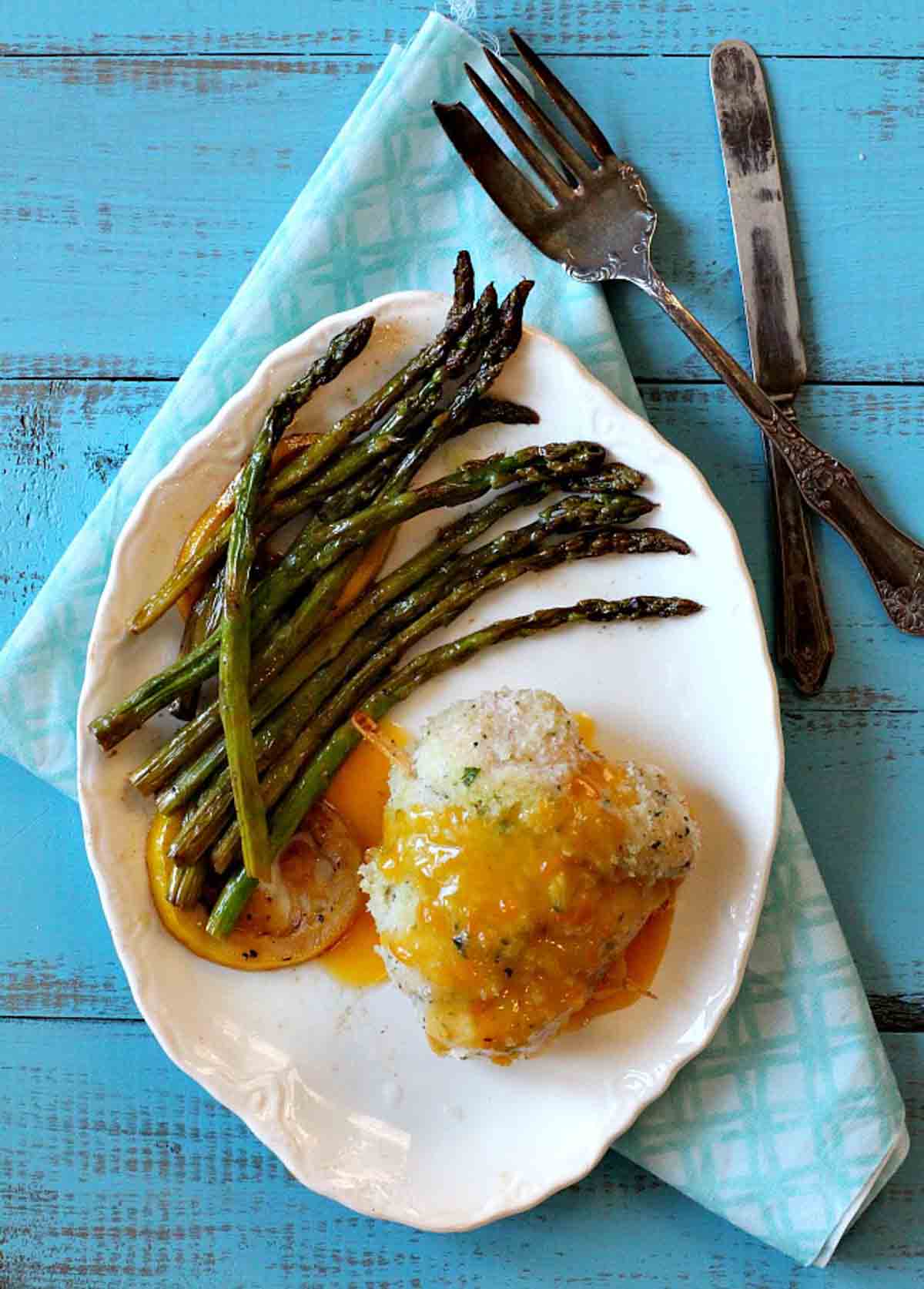 Chicken cordon bleu served with apricot sauce and asparagus.