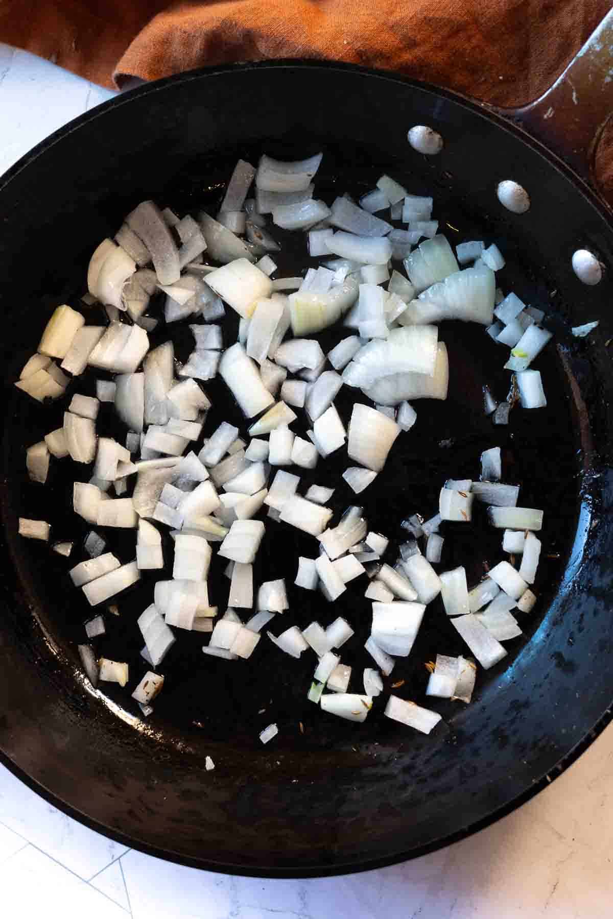 Step 3: cooking chopped onions to make red chile sauce.