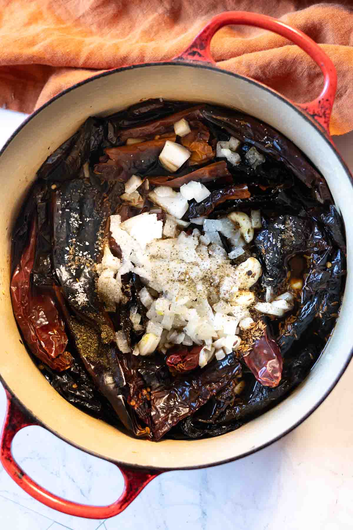 Step 5: Adding remaining ingredients to cooked chile pepper pods to make red chile sauce.