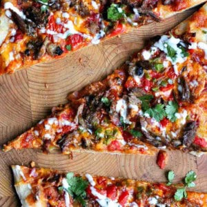 Three slices of brisket pizza on a cutting board.