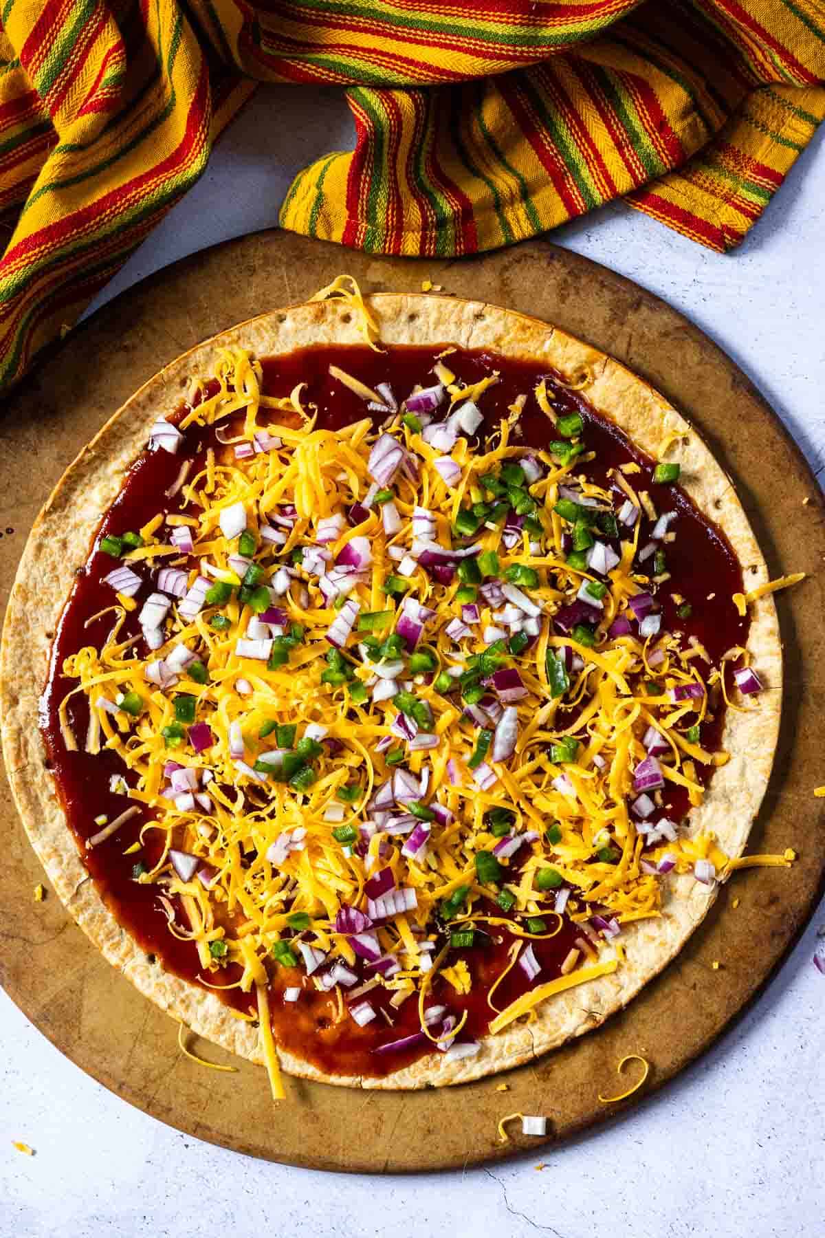 Step 3: Adding jalapeno pepper and chopped onion to make brisket pizza.