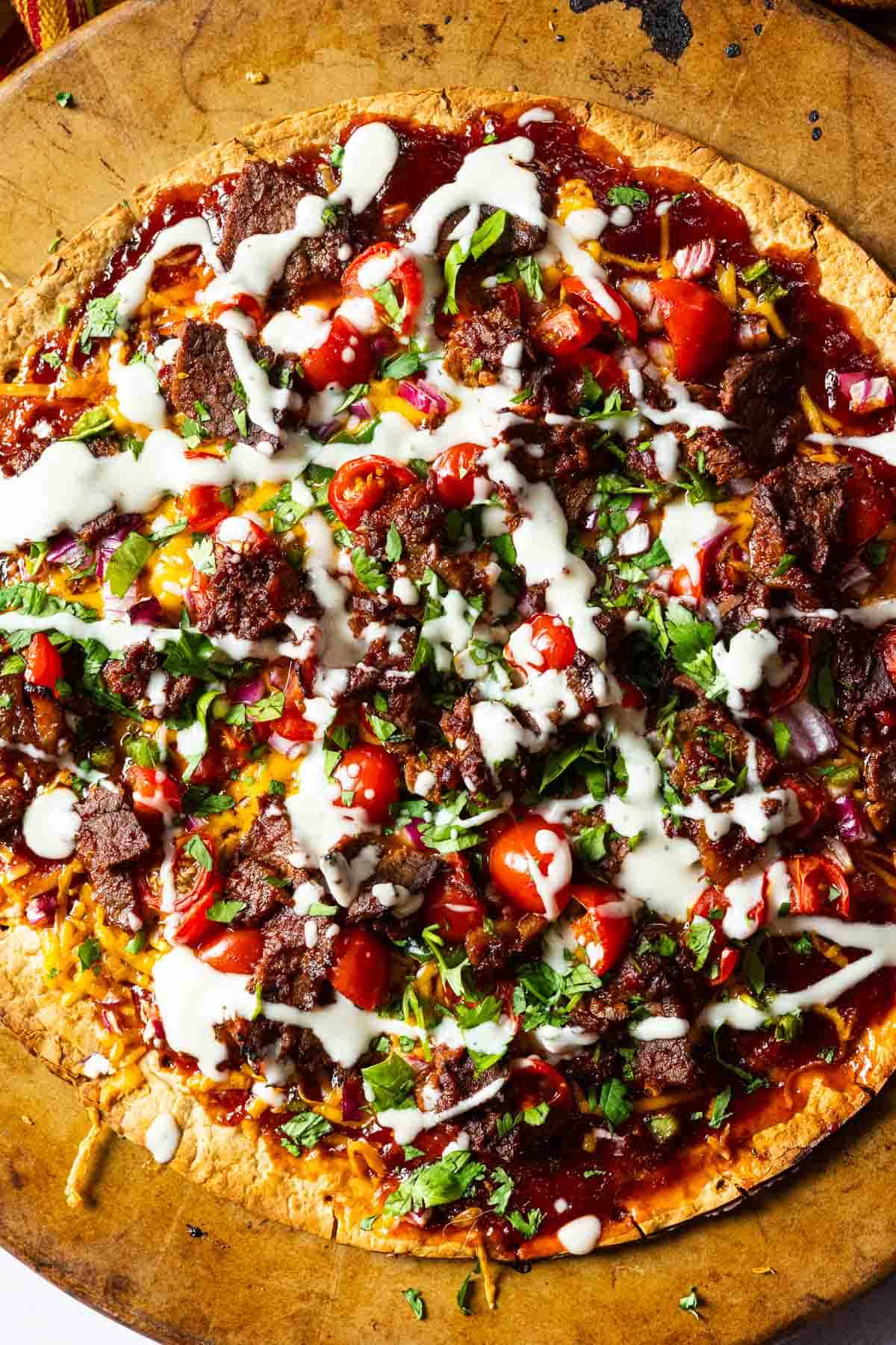 Step 6: Cooked Brisket pizza topped with Ranch Dressing and Cilantro.
