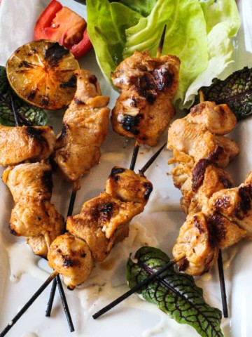 easy grilled chicken kebabs on a platter garnished with lettuce