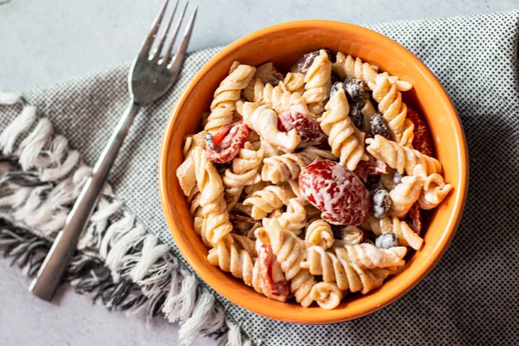 Rotini pasta salad with black beans and cherry tomatoes.
