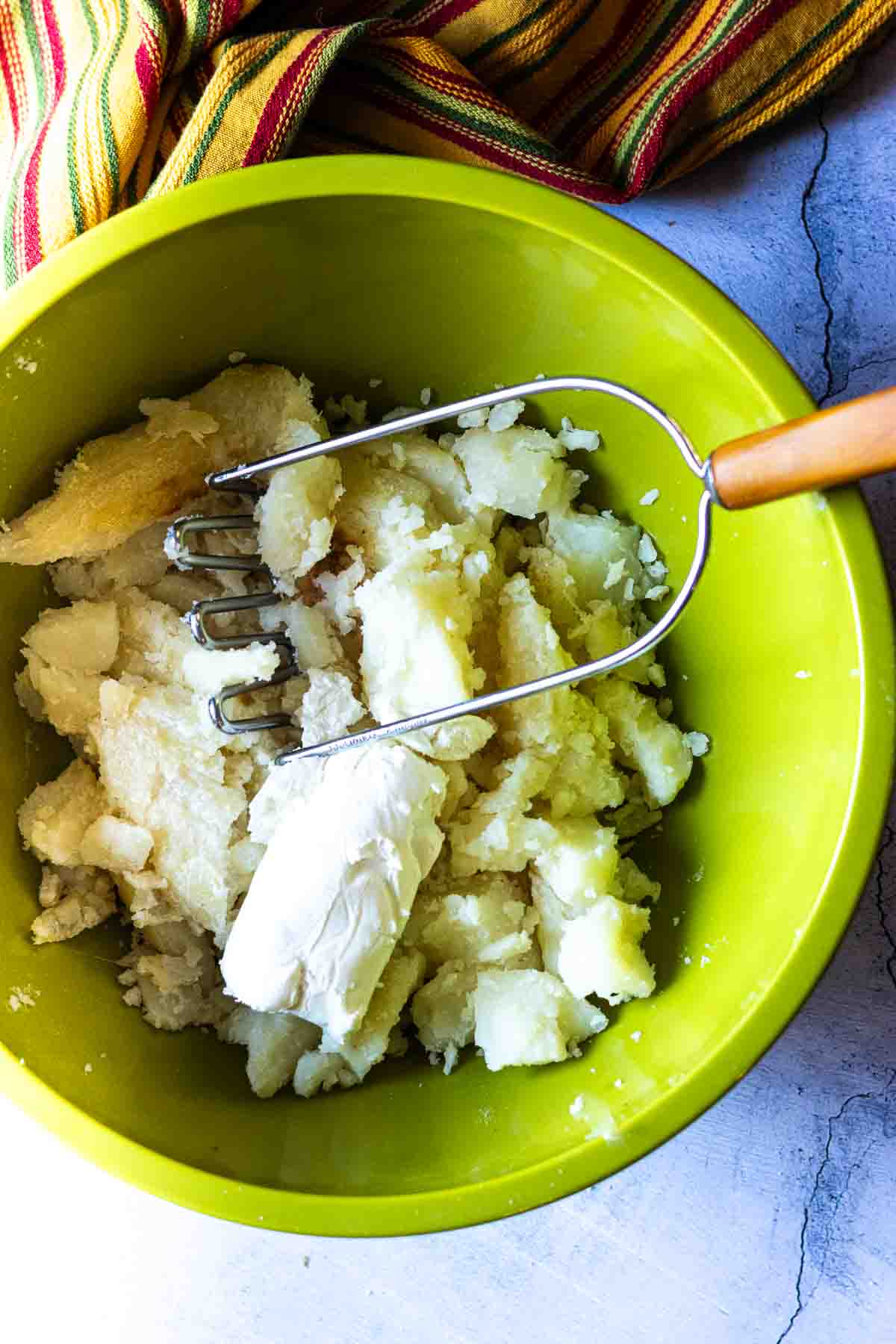 Smashing potatoes to make stuffed poblano peppers.