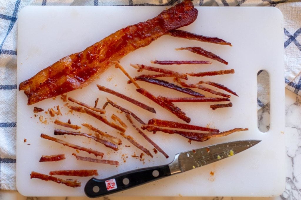 Cutting cooked bacon into very thin strips