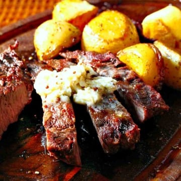 Whiskey compound butter for steak served over steak with potatoes.