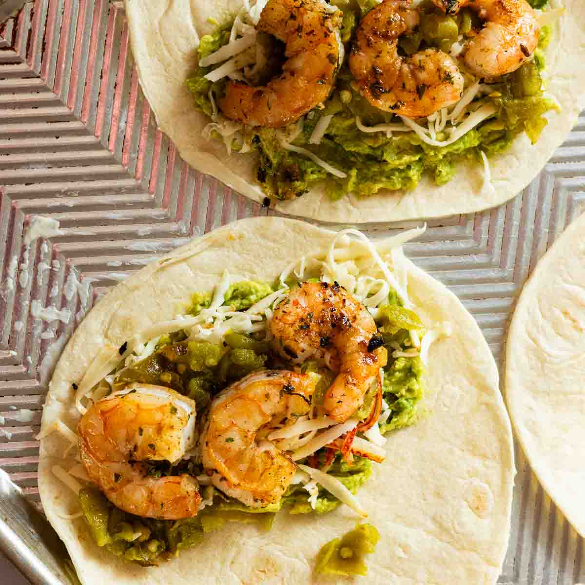 Adding shrimp to flour tortillas to make shrimp quesadillas.
