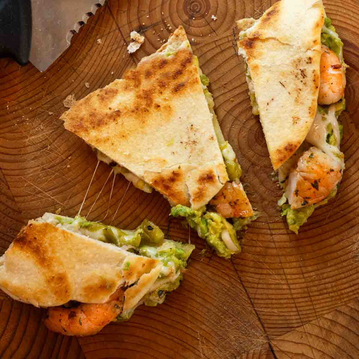 Cutting shrimp quesadillas with a serrated knife.