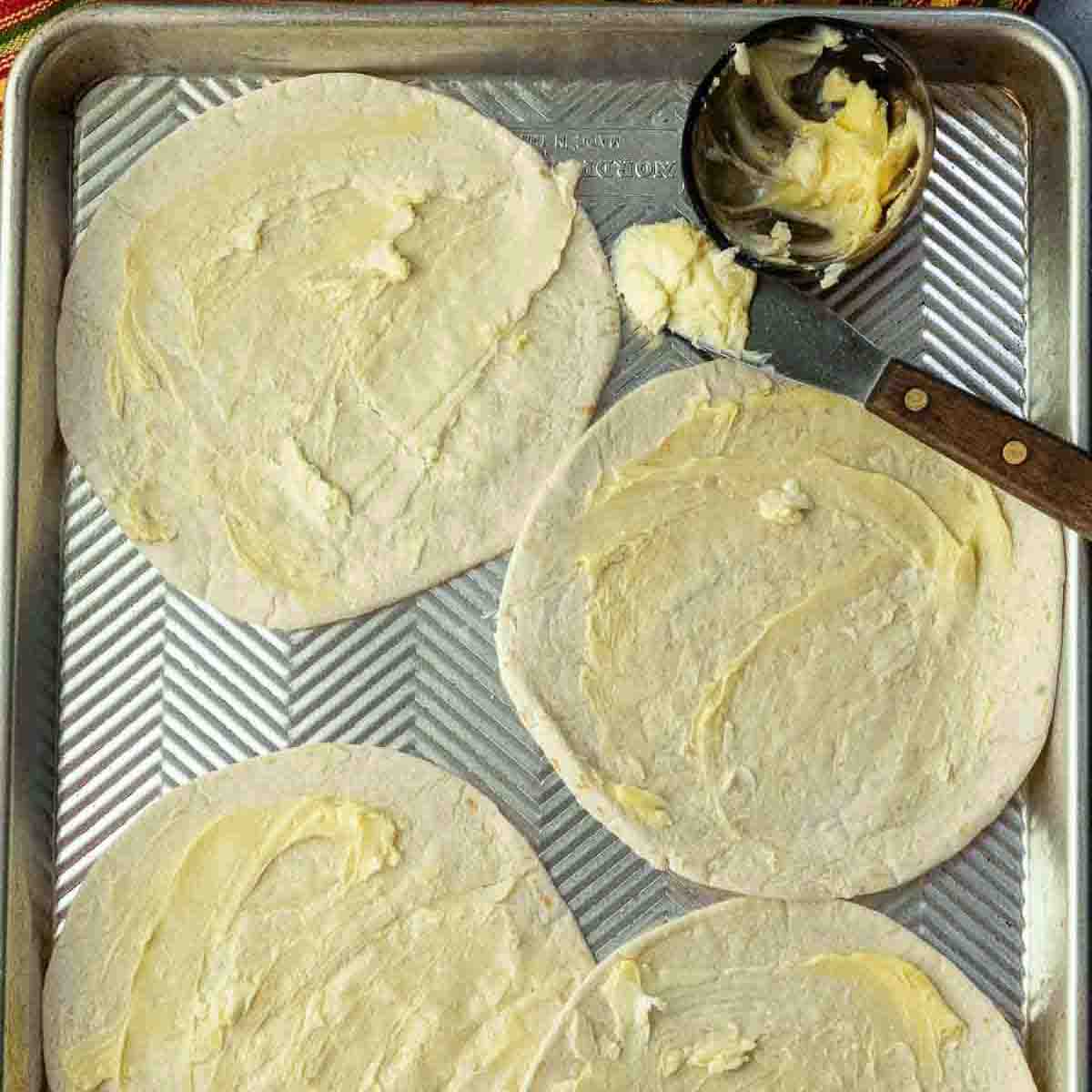 Buttered flour tortillas to make shrimp quesadillas.