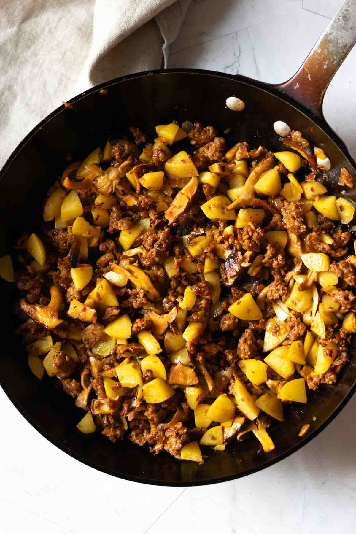 Skillet of fried potatoes, mushrooms, and chorizo to make chorizo tacos, step 4.