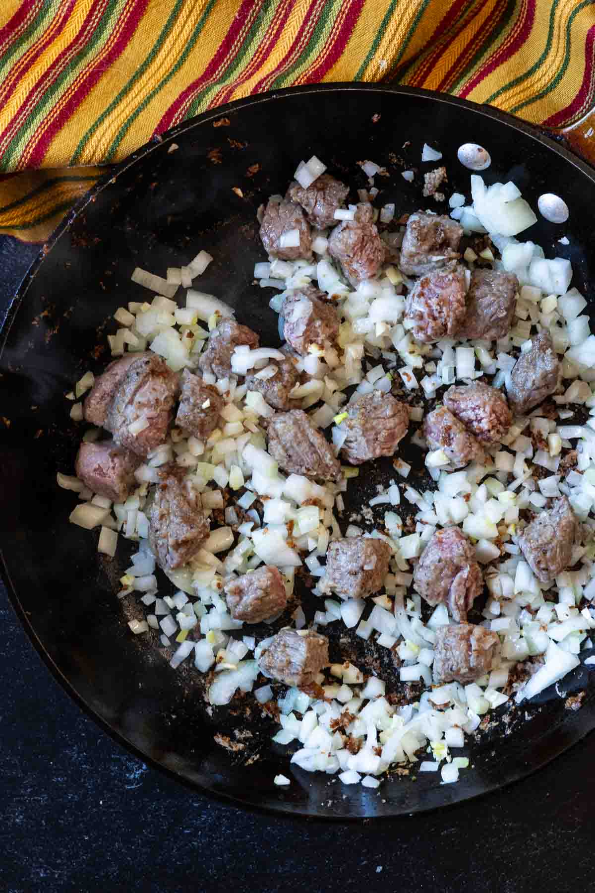 Searing stew meat and onions to make chuck roast chili.