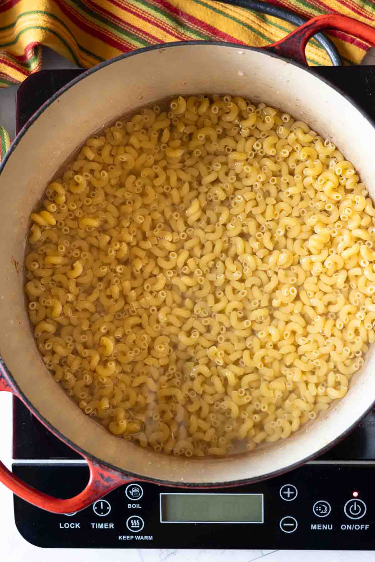 Step 3: Cooking elbow macaroni to make macaroni and cheese with chicken.
