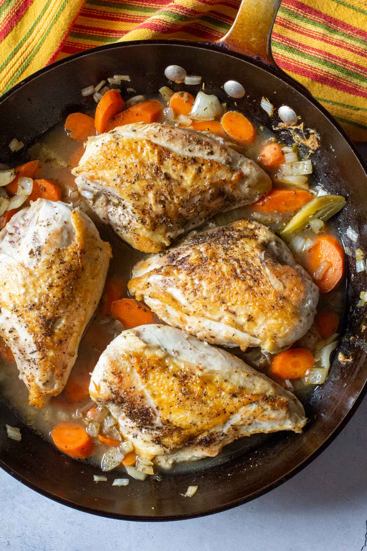 Cooking chicken with vegetables for pollo escabeche.