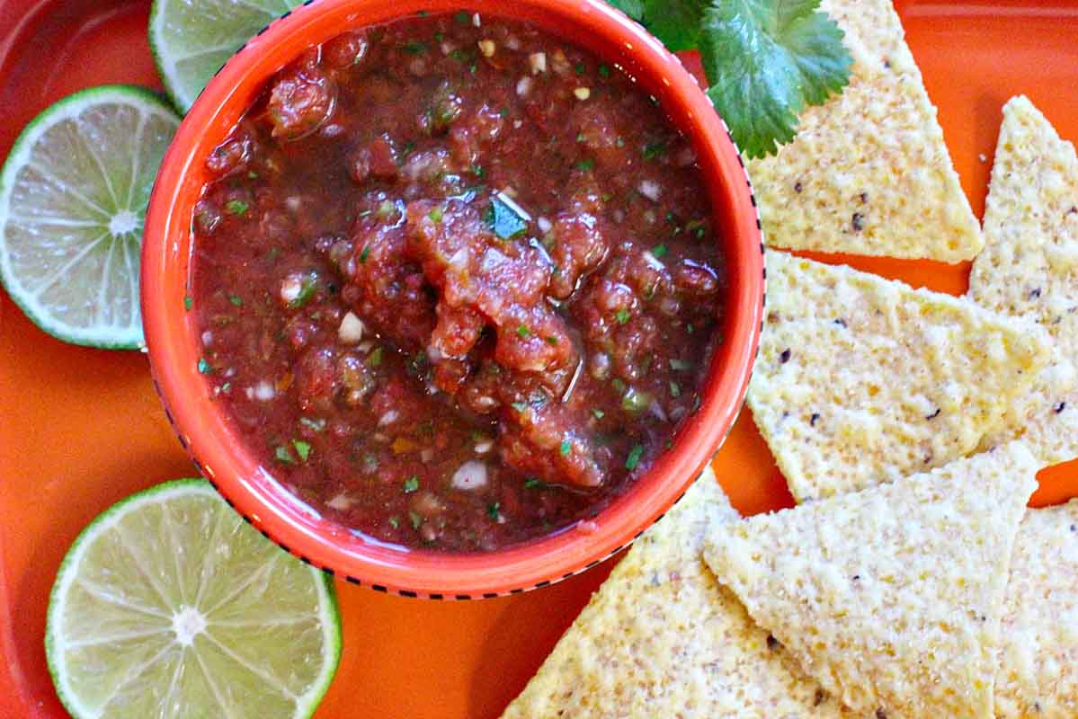 Homemade Restaurant style salsa in a Mexican style bowl with chips.