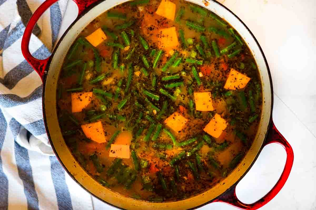 Finishing chicken and vegetable soup with white wine.