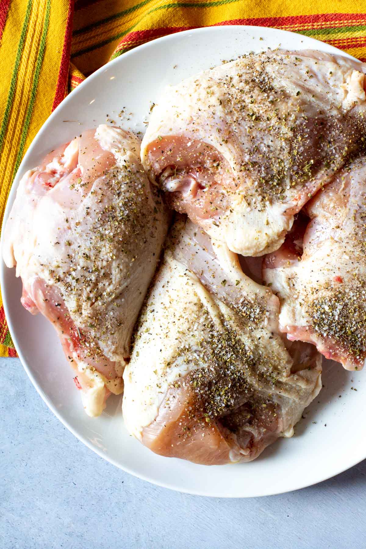 Seasoning chicken breasts to make pollo en escabeche.
