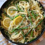 Angel hair pasta with asparagus and lemon in a large fry pan.