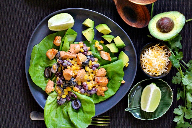 Mexican salad recipe served on bibb lettuce and topped with chicken, kidney beans, sweet corn, olives and avocado