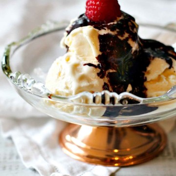 Mexican chocolate sauce over vanilla ice cream topped with a raspberry.