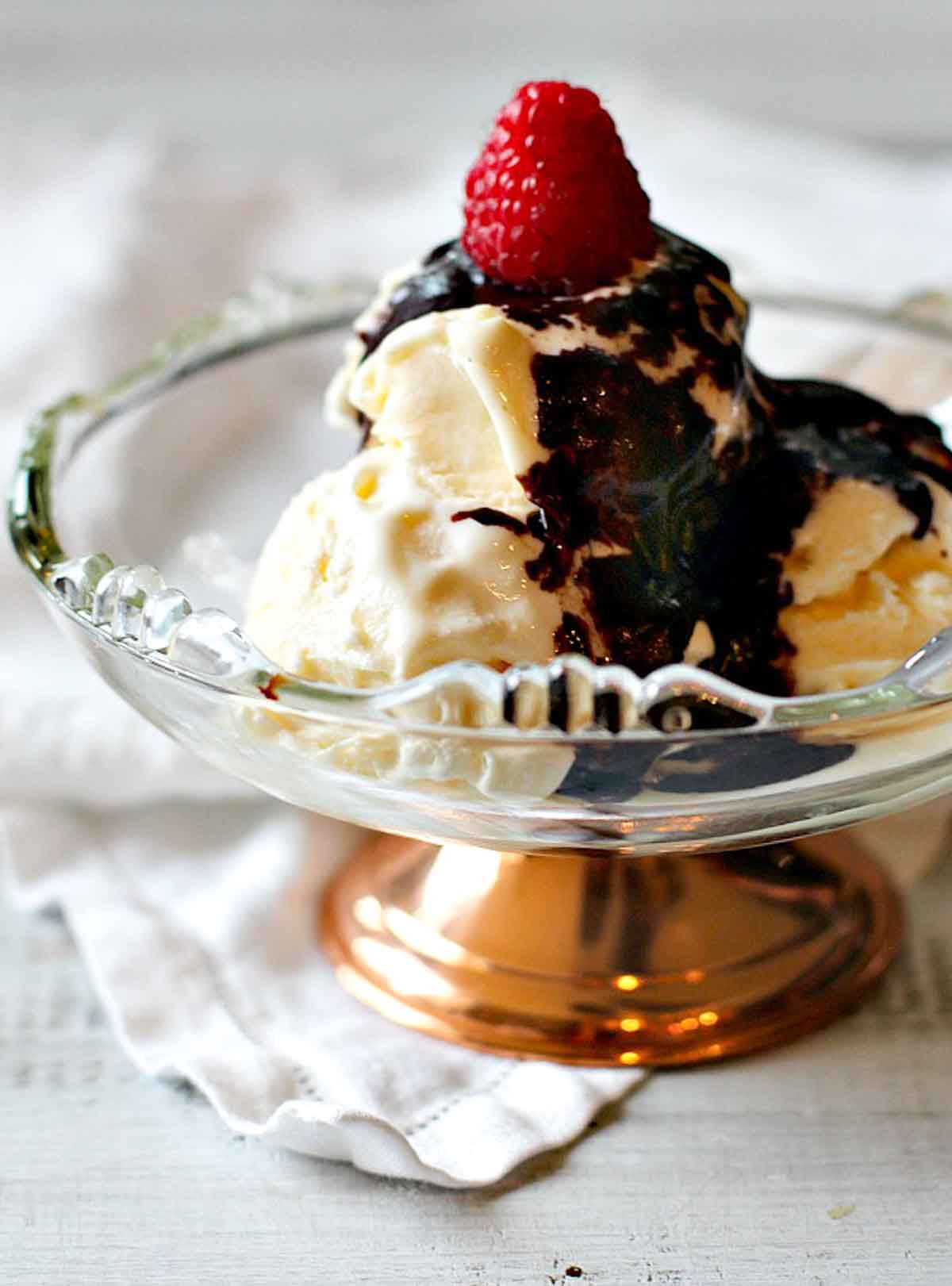 Mexican chocolate sauce over vanilla ice cream topped with a raspberry.