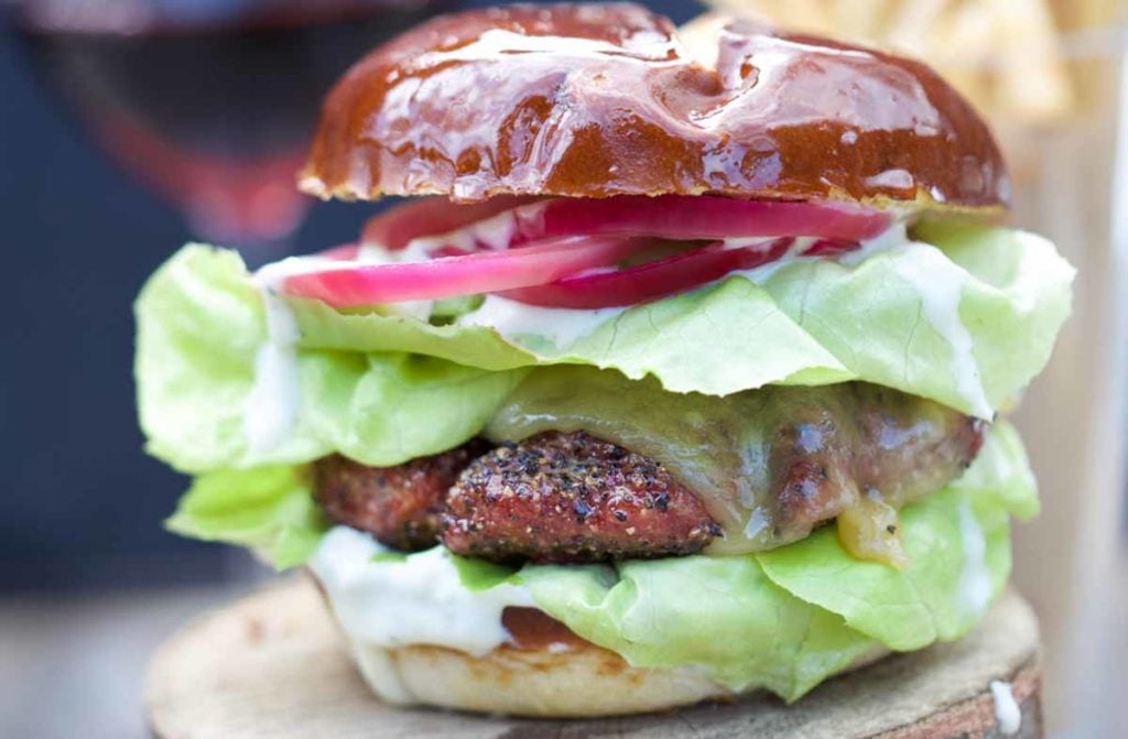 Smoked lamb burger with lettuce and tomatos.
