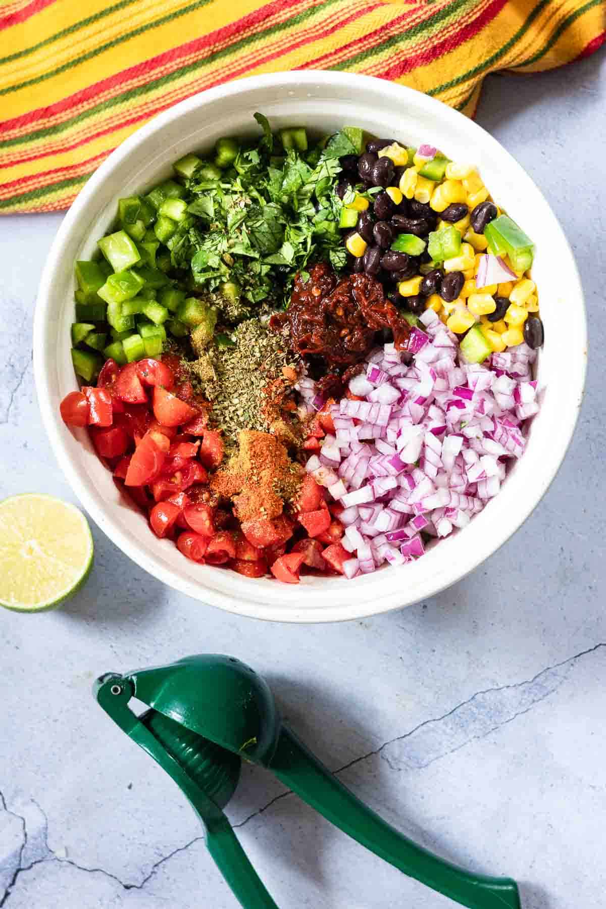 Making black bean corn salsa dip in a large bowl.