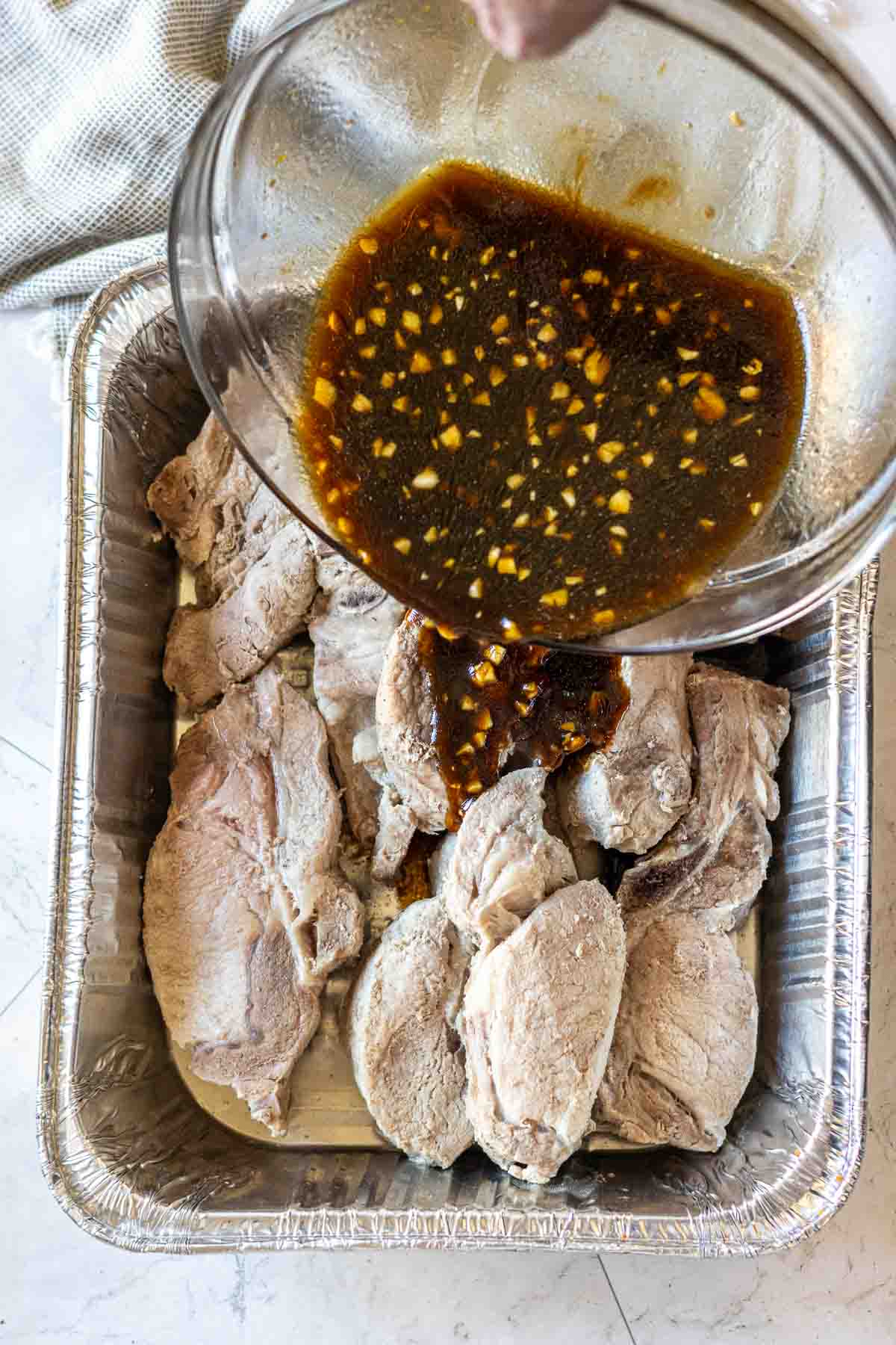 Step 4: Pouring marinade over country style pork ribs.