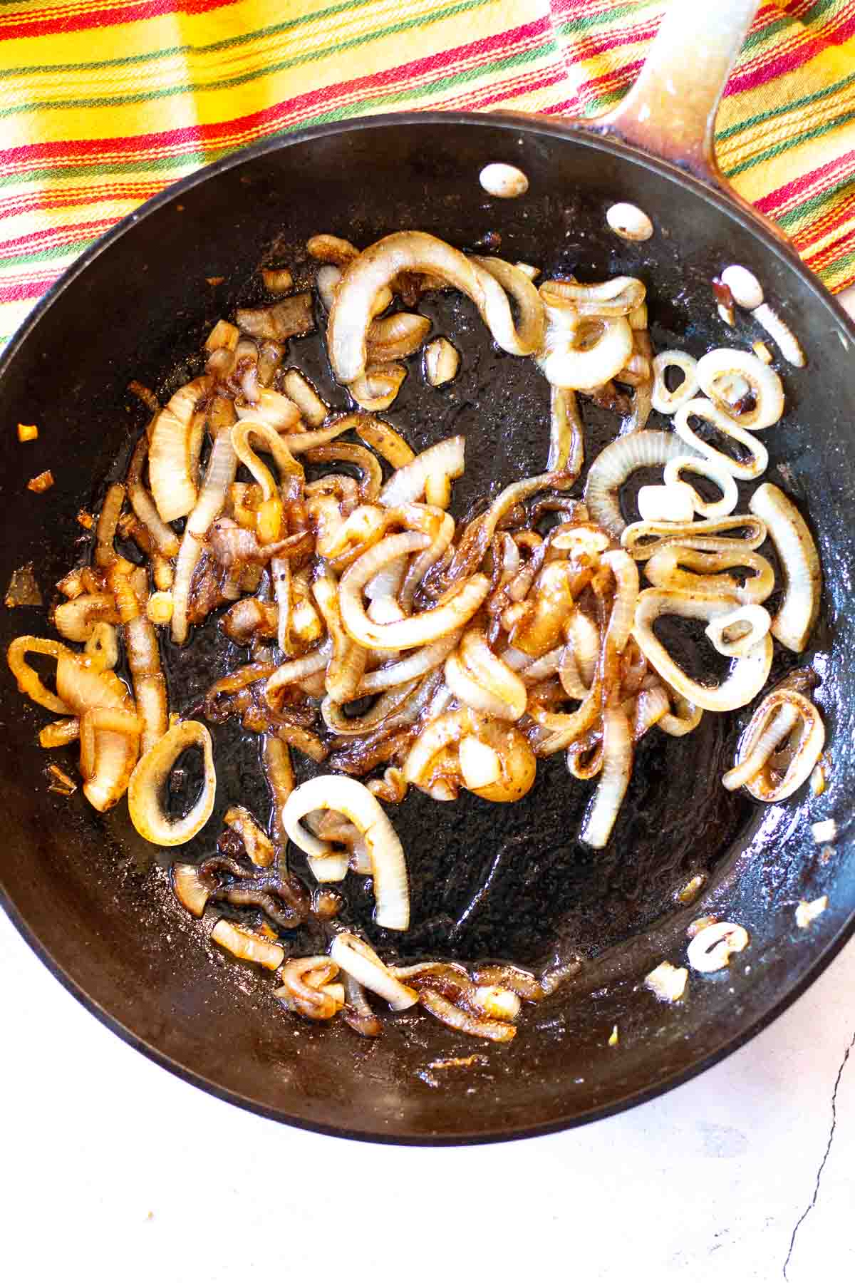 Caramelizing onions in a large fry pan to make a caramelized onion tart.