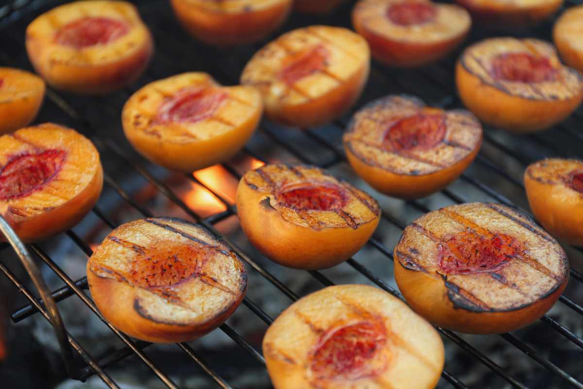 Grilling peach halves on a grill.