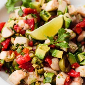 A bowl of halibut ceviche topped with a slice of lime.