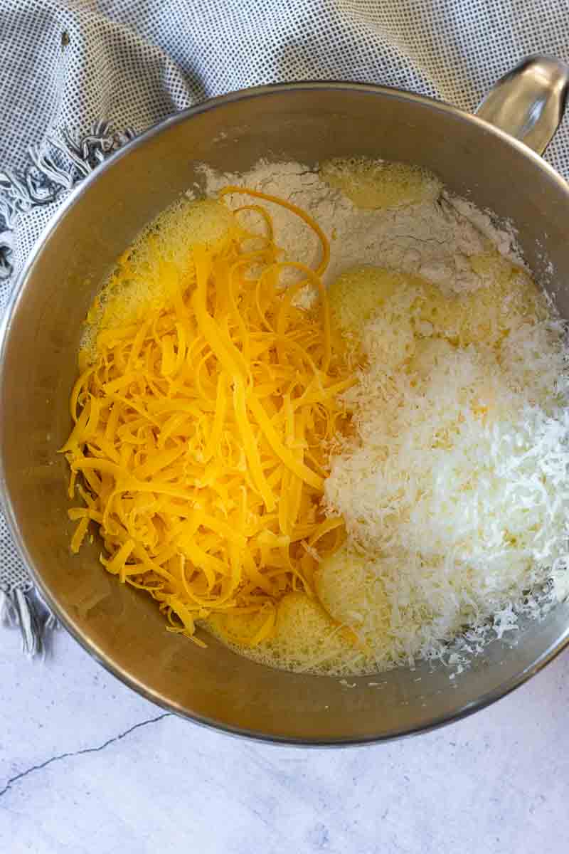 Combining eggs and cheese to make Italian Breakfast Casserole.