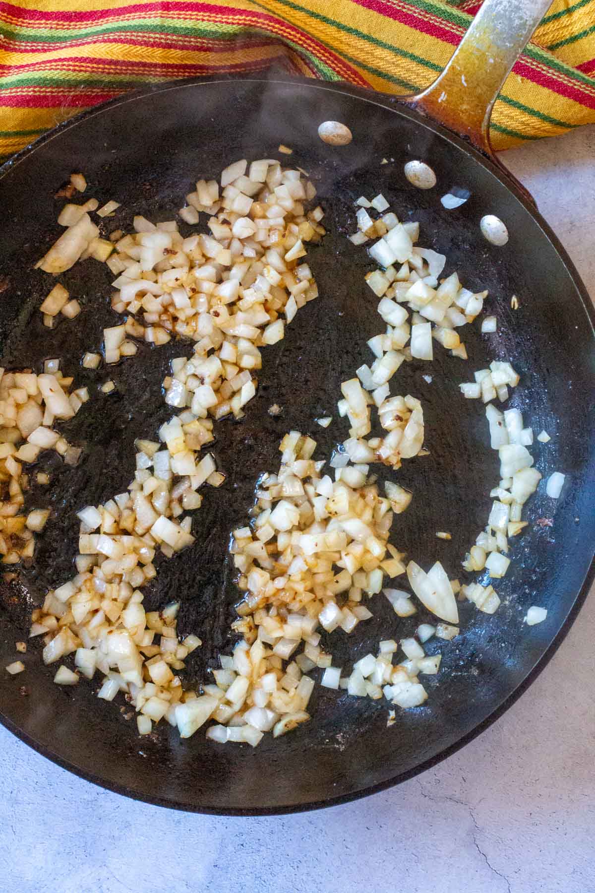 Browning chopped onions in a large black skillet.