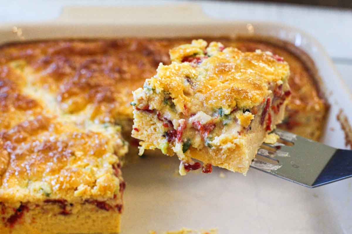 A slice of three cheese egg casserole on a spatula.