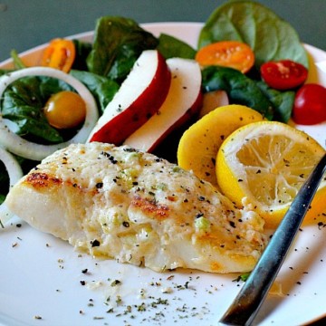 Baked Halibut Recipe topped with mayonnaise and served with a side salad