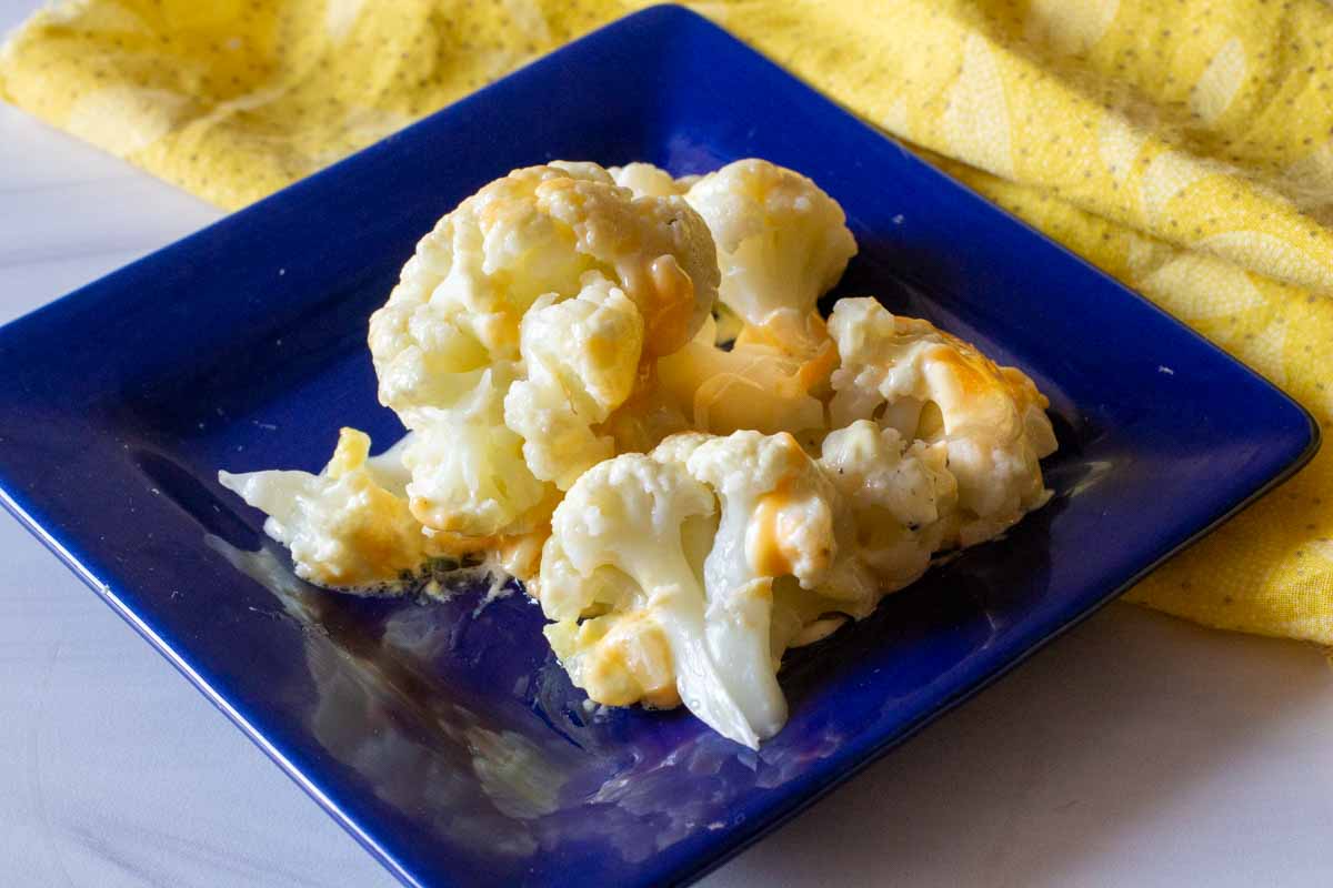 Whole cauliflower cooked in the microwave served on a blue plate