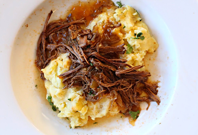 Crock pot cola BBQ brisket served over mashed potatoes