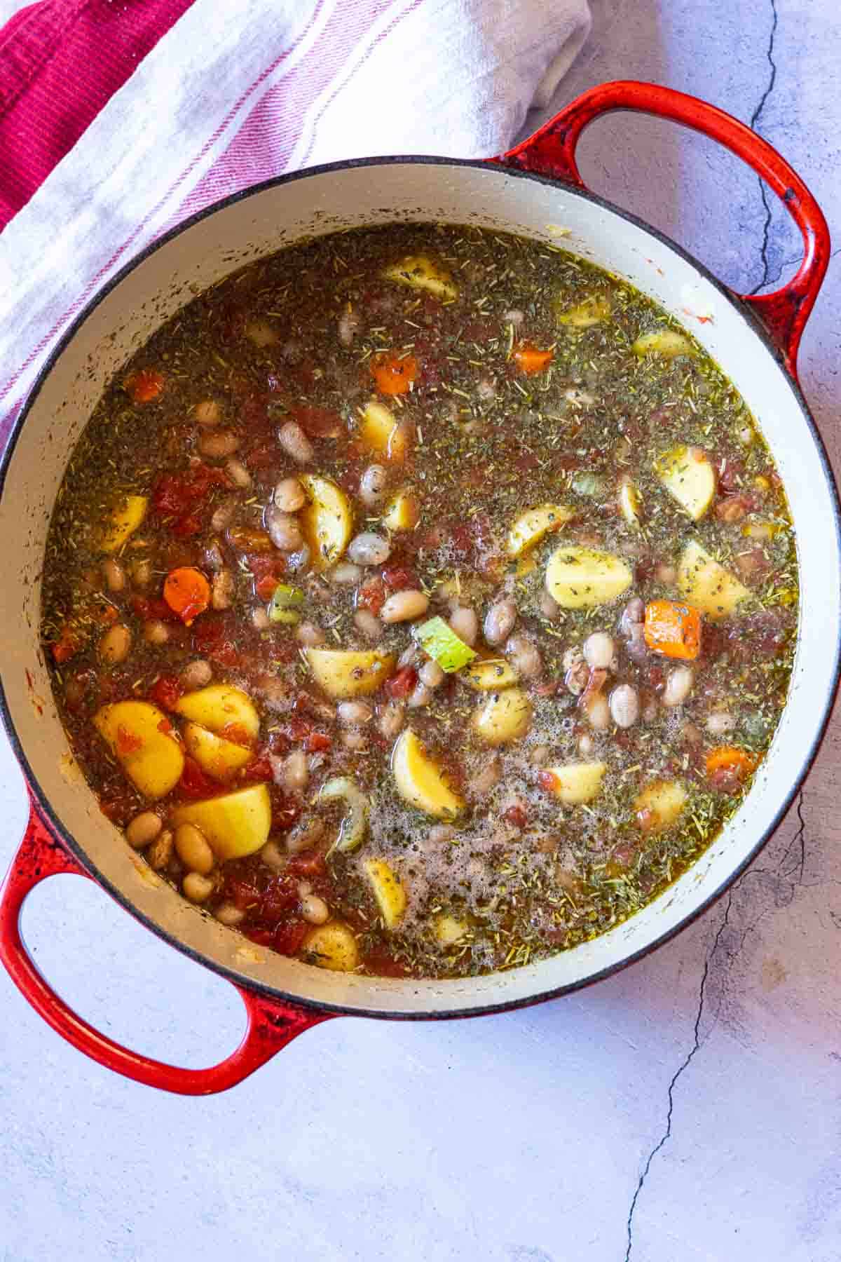 Adding ingredients to Dutch oven to make mayocoba bean soup.