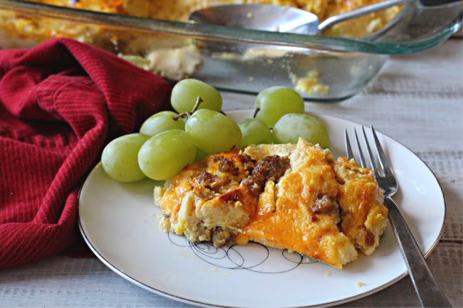 sausage egg cheese casserole on a vintage 1950's china plate with fresh green grapes
